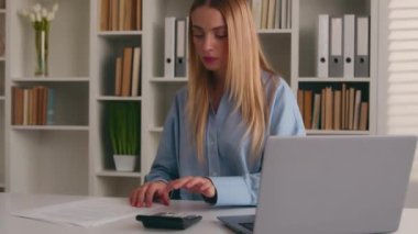 Kafkas kadın iş kadını hesap makinesi ve dizüstü bilgisayar uygulaması kullanarak ofis evraklarını kontrol ederek para kazanmayı, iş harcamalarını, kadın muhasebeci ve finans yönetimi işlerini hesaplıyor.