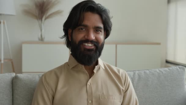 中東の30代の多民族のアラビア人のひげを生やした男イスラム教徒の男の自家所有者のフリーランスのビジネスマン自宅で ポートレート笑顔幸せなインドの男性賃貸マンションの夫陽気な笑顔 — ストック動画