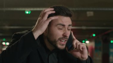 Sinirli Kafkasyalı iş adamı konuşuyor cep telefonu agresif erkek yönetmen yeraltı otoparkında bağırıyor iş anlaşmazlığı hücresi kavgasını çözüyor cep telefonu kavgasını arıyor öfke duygusunu tartışıyor bağırıyor