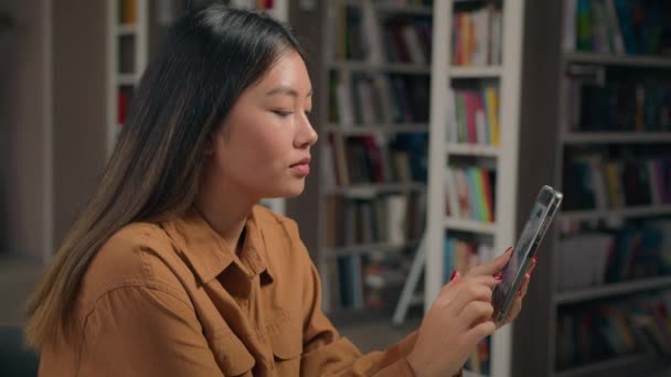 Asiatische Studentin Der Universitätsbibliothek Kommuniziert Videolink Mit Handy Junge Frau — Stockvideo