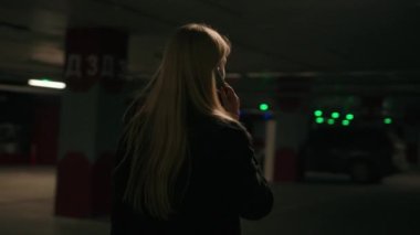 Kızgın kadın işkadını müşteri şoförü yeraltı otoparkında yürüyor cep telefonu çalıyor taksi çağırıyor kötü servis arkası görüntüsü tanınmayan bir kız çığlığı cep telefonu kavgası.