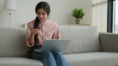 Kadın müşteri çevrimiçi banka kredi kartıyla alışveriş yapıyor dizüstü bilgisayardan mal satın alıyor güvenli finansal internet ödemesi e-ticaret mutlu Arap kız dijital para ödüyor eve internet sitesi siparişi teslimatıyla