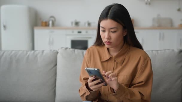 伤心失望的女人在厨房里的亚裔华裔女士在聊天应用程序上看到坏消息手机故障连接错误故障拒收电子邮件丢失的智能手机问题 — 图库视频影像