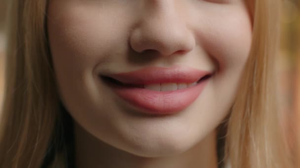 闭上女性丰满的嘴唇用口红妆容光滑的皮肤面容难以辨认的女孩微笑健康的牙齿白牙护理牙科美容外科透明质酸注射器 — 图库视频影像