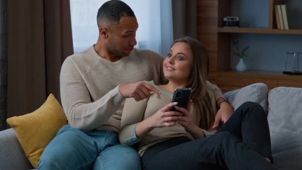 Multiracial Couple Customers Relax Sofa Use Mobile Phone Home Diverse — Stock Video