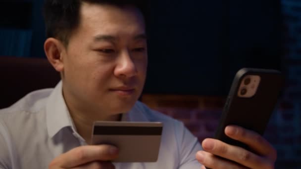 Glad Asiatisk Man Mörk Kväll Hemmakväll Med Mobiltelefon Med Kreditkort — Stockvideo