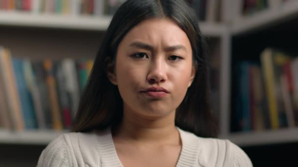 女性の肖像画動揺悲しいアジアの女性学生見ますカメラで落ち込んでいるフラストレーション表現で大学図書館絶望的な女の子女性感じます悲しみのために失敗した結果試験を受け悪いニュース — ストック動画