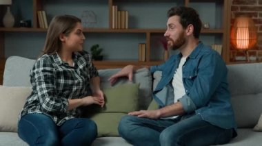 Kafkasyalı çift oturma odasında kanepede oturup dertsiz tasasız bir şekilde konuşuyor heyecanlı haberleri paylaşıyor kız arkadaşla konuşuyor komik fıkra anlatıyor komik kadın evde gülen adam diyaloglarına kulak veriyor.