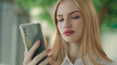 Ciddi bir kadın internet 'te akıllı telefon Kafkasyalı iş kadını iş dünyası sosyal medyası okuyor cep telefonundaki alışveriş uygulamaları için cep telefonu uygulamaları kullanarak mesajlar yazıyor.