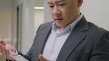 Orta yaşlı Çinli işadamının cep telefonuyla Asyalı bir adamı vurarak internet üzerinden mesajlaşması sosyal ağlar, akıllı telefondan kötü haberler alıyor.