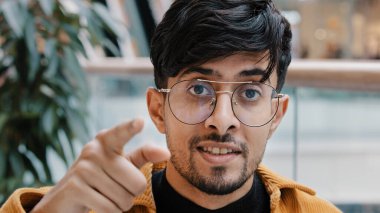 Yakın plan Hintli sakallı adam kameraya işaret parmağıyla işaret parmağıyla işaret ediyor. Kendine güvenen genç Arap adam müslüman erkek işadamının davet edildiği yönü gösteriyor. Kısmen kurumsal takım olmayı seçiyor.