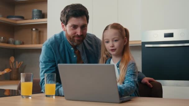 親の制御白人の父親は家庭用キッチンのお父さんでラップトップアプリを使用して小さな娘を教えるコンピュータソフトウェアのヘルプを説明します — ストック動画