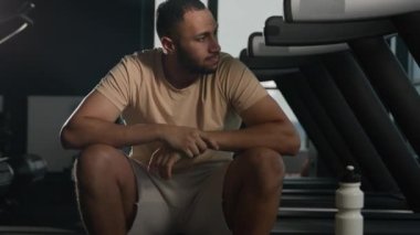 Yorgun Afrikalı Amerikalı sporcu spor salonuna ara verdi. Yorgun, terli, zor nefes alıyor. Kardiyo egzersizinden sonra dinleniyor.