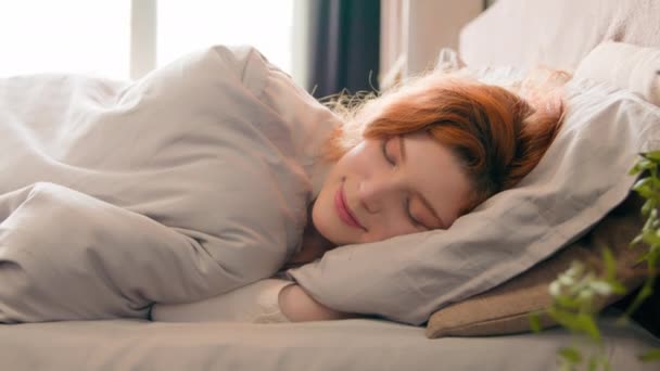 白种人快乐女人睡在舒适舒适舒适的床上睡在柔软的枕头上睡在白色亚麻布整形外科床垫上休息放松打盹降睡眠缓解晨间压力 — 图库视频影像