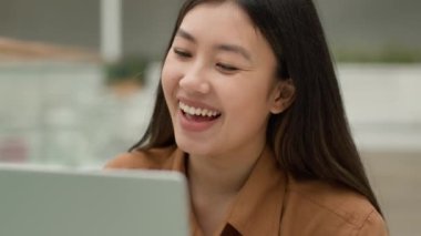Asyalı Çinli kadın internetten bilgisayarla video görüşmesi internet iletişimi mutlu gülümseyen iş kadını kız öğrenci konuşması sanal sınıf e-öğrenim web kamerası uygulaması video konferansı çağrısı