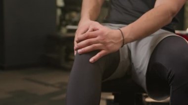 Afrikalı Amerikalı çoklu etnik kökenli sporcu kas ağrısı çekiyor sporcu vücut geliştirme sporcusu masaj yapıyor, diz masajı yapıyor spor salonu egzersizinden sonra travma esnetiliyor ciddi ağrı krampları var.