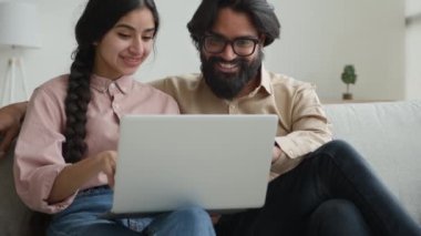 Heyecanlı mutlu çift evde dizüstü bilgisayarda e-posta okuyor harika haberleri kutluyorlar beşlik bahsi kazanın zafer için kredi alın Hintli Arap kadın etnik erkek online başarı mortgage onayını kutluyor