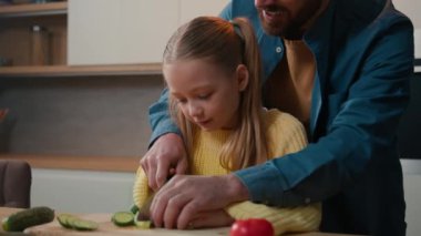 Baba, küçük kızına bıçaklı salatalık kesmede yardım et baba, 10 'luk çocuğa vejetaryen salatası yapmayı öğret.
