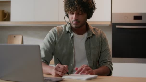 Hombre Indio Con Auriculares Sentado Cocina Estudiando Notas Escritura Línea — Vídeos de Stock