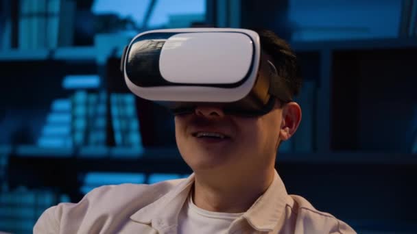 亚洲成年男子采用现代技术探索虚拟现实 晚上回家时戴Vr眼镜的韩国男子戴3D护目镜玩游戏 晚上在沙发上玩多样化模拟游戏 — 图库视频影像