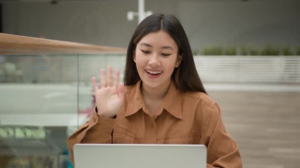 アジアの女性社員起業家は ラップトップコンピュータ上で話すオンラインビデオ通話距離は 仮想ウェブカメラチャットで呼び出し笑顔中国語韓国語日系企業の女性労働者は カフェで座って話す — ストック動画