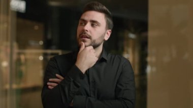 Modern ofisteki düşünceli bir işadamı iş dünyasının ilham verici sorunlarını çözmeyi düşünüyor. Kafkasyalı zeki adam yaratıcı tasarımcı parmak kaldırıyor. 