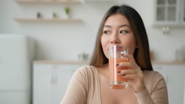 Çinli Koreli bir kadın evde şeftali portakal suyu içiyor Asyalı bir kızın bir bardak meyveli smoothie içtiğini hayal ediyor düşük kalorili vitaminler kokteyl, sağlık hizmeti, kilo kaybı detoks