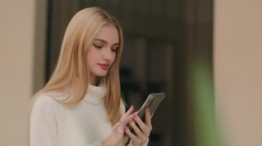 Alış veriş merkezinin başarılı iş kadını müşterisi AVM 'de yürüyen beyaz kadın müşteri akıllı telefondan akıllı telefon alımıyla mesaj yazan başarılı iş kadını.