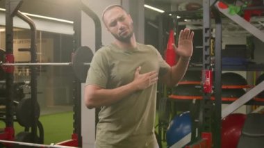 Mutlu Afrikalı Amerikalı erkek kaslı spor antrenörü spor kulübü eğitmeni Latin sporcu dans ederken eğleniyor spor aletlerinin yanındaki müzik ritmine ayak uyduruyor.