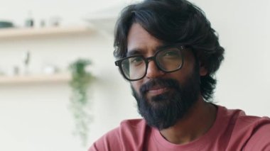 Etnik Arap Hindistanlı akıllı adam gözlüklü ev sahibi kiracı 30 'lu yaşlarda gözlüklü yakışıklı Müslüman adam kameradan memnun gülümseyen sakallı koca mutfakta.