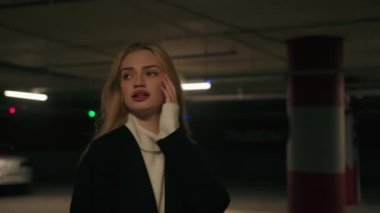 Kafası karışmış Kafası karışmış Kafkasyalı kadın karanlık araba parkında yalnız başına tehlikeli bir savaş tehdidi aramaktan korkmuş kadın iş kadınının yeraltı sığınağında kaybolmasına yardım ediyor panik stresi yaşıyor.