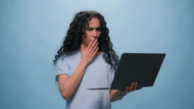 Şok olmuş Hintli öğrenci Latin bayan iş kadını bilgisayar arızası yüzünden üzgün. Bilgisayarda şok yaşandı. Kötü haberler, internet sorunları... Stüdyo mavi arka planda sınav sonuçları başarısız oldu.