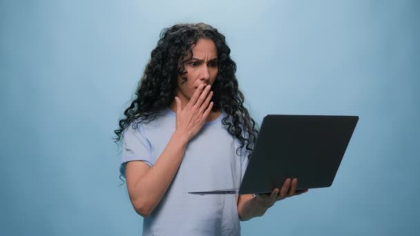 惊慌失措的印度女学生拉丁裔女商人因电脑故障而心烦意乱的女商人用笔记本电脑强调震惊坏消息在线问题在工作室蓝色背景下考试成绩不及格 — 图库视频影像