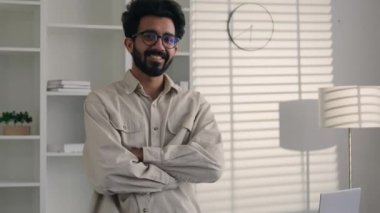 İş portresi Hintli Arap sakallı erkek serbest çalışan yönetici merkez ofiste kollarını kavuşturdu mutlu Müslüman milenyum adamı kameraya bakan kendinden emin gülümseyen dişlek iş adamına baktı