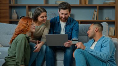Heyecanlı takım erkekleri, çeşitli kadınlar, online ödemeler için kredi kartı kullanıyor. Bilgisayar, etnik çeşitliliğe sahip iş adamları, iş arkadaşları, kazananlar, para kazanıyor. Zafer indirimleri, nakit para kazanıyorlar.