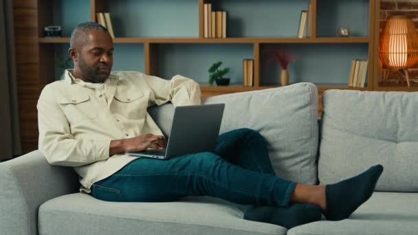 Homme Mûr Afro Américain Couché Sur Canapé Détendre Aide Ordinateur — Video