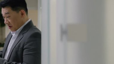 Koridorda çekilen iş adamı orta yaşlı Asyalı Çinli iş adamı cep telefonu bahsi kazanan çok ırklı iş adamı online piyango kazananı çığlık çığlığa başarı kazandı