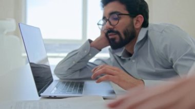Çok ırklı iş adamları motivasyonsuz şirket çalışanlarının sıkıcı dizüstü bilgisayar işinden dikkatleri dağılmış şekilde oturup cep telefonu oyunu oynamaları sıkılmış tembel iş adamları düşük enerjili işkadınlarının uykuya daldığını hisseder.