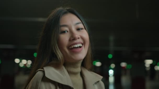 幸せなアジアの多民族の女の子中国の韓国の女性日本のビジネス女性の運転手の肖像画満足クライアントは都市の暗い駐車場で誠実な笑い笑い笑顔楽しい冗談歯科歯の笑顔を持っています — ストック動画