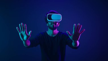 Metaverse sanal gerçeklik siber uzay adamı oyun oynuyor adam meta evren dijital teknolojiyi VR gözlükleri miğferinde siber oyuncu neon mor ötesi fütüristik uzay siber punk oyunu ile deneyimliyor