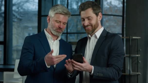 Dwóch Kaukaskich Przedsiębiorców Partnerzy Biznesowi Koledzy Porozmawiać Wygląd Ekranu Telefon — Wideo stockowe