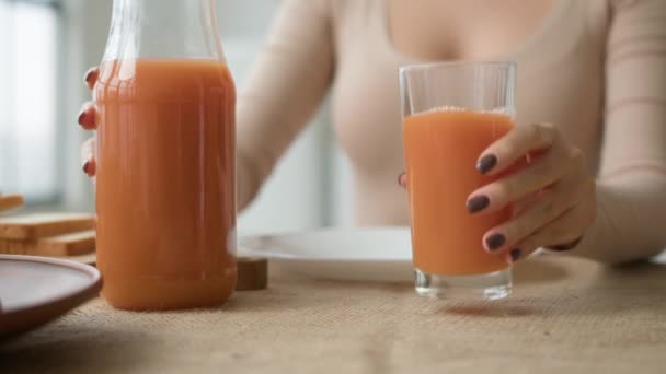 生机勃勃的女人喝着一杯橙桃新鲜果汁蔬菜冰沙鸡尾酒在厨房桌子上喝着健康的天然维生素有机减肥餐排毒保健 — 图库视频影像
