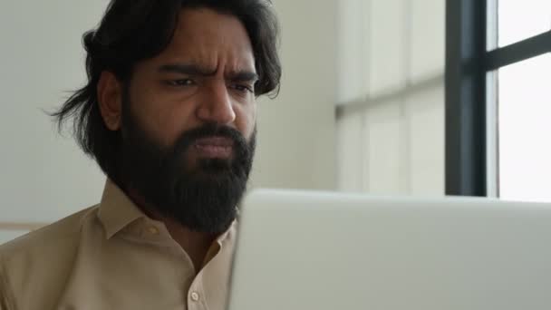 ストレスを受けたインド人髭男は自宅のオフィスでラップトップでオンラインで働いています男性アラビア人イスラム教徒のビジネスマン心配問題コンピュータが仕事を失った破産ビジネスプロジェクトの失敗疲れ動揺男失う — ストック動画