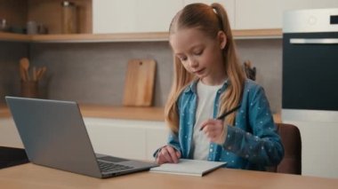 İnternet öğretmeniyle uzaktan eğitim almak evde karantina altına almak e-öğrenim gören küçük öğrenci öğrenci öğrencisiyle mutfak laptopunda çalışmak online sınıf kızı ödevi