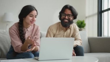 Gülümseyen Arap iş adamı çift Müslüman kadın görüntülü konuşma webcam laptop konferansı ev ofisindeki çok ırklı erkek kız arkadaş canlısı sanal sohbet karantinada gülüşmeler