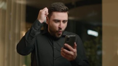 Şok olmuş mutlu beyaz erkek kazanana bak akıllı telefon ekranı kazan hedef para ödülü kazan cep telefonu piyangosunu kazan iş adamı heyecanlı müşteri zaferini online olarak kutluyor