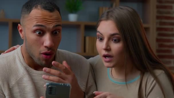 Choqué Heureux Couple Multiracial Regardant Écran Téléphone Portable Lire Les — Video