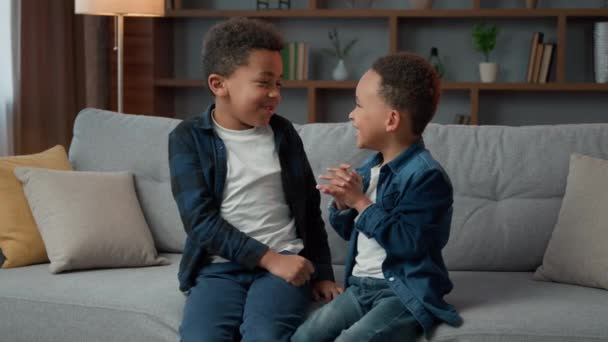 两个小男孩兄弟 孩子们 孩子们 孩子们 孩子们 在沙发上聊天 男孩私语 谈论友谊 家庭感情 — 图库视频影像