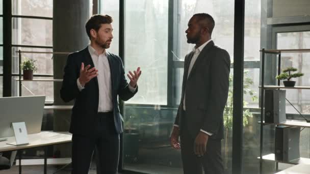 オフィスで話す2人の多民族のビジネスマン多民族の同僚男性ビジネスパートナーは 企業取引について話し合う白人ビジネスマンとアフリカ系アメリカ人雇用主の会話交渉 — ストック動画