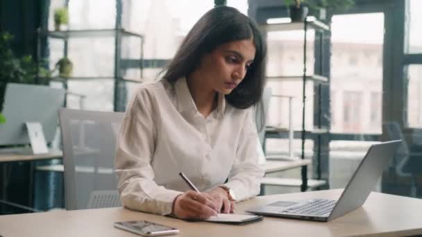 Multirracial Mulher Negócios Séria Escritório Trabalhando Com Laptop Escrita Notas — Vídeo de Stock